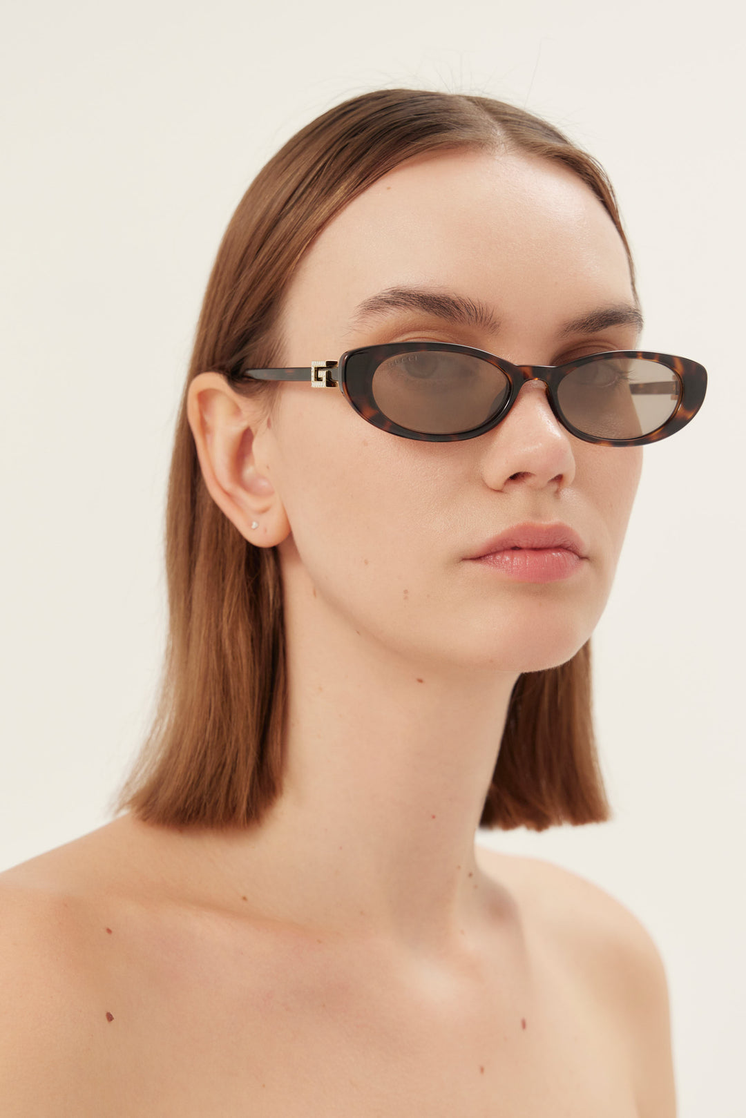 PRE-ORDINE - Occhiali da sole Gucci ovali cat-eye marroni e grigi con logo dorato
